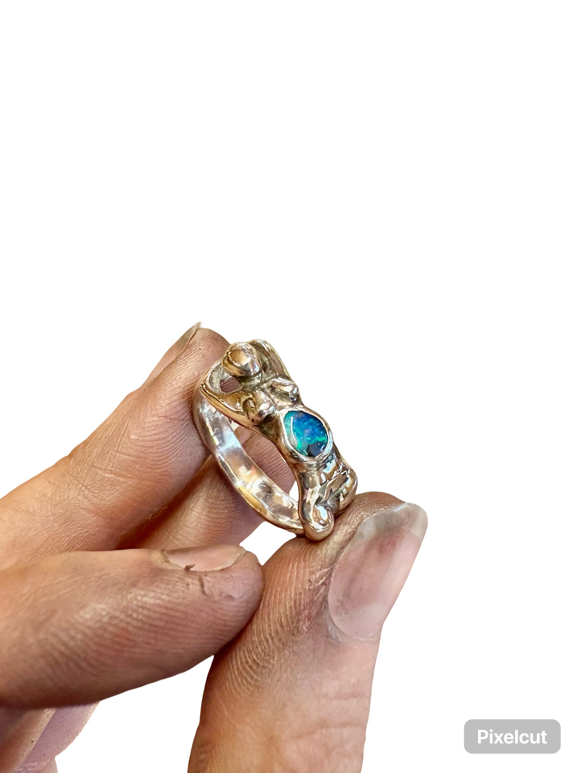 Silver  nude female body ring with 
boulder opal gemstone on a bed of green moss