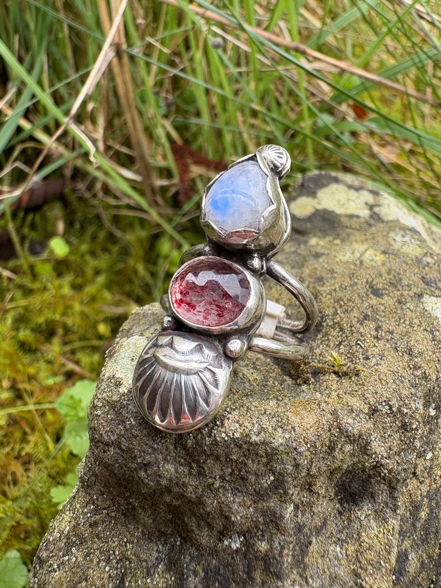 handmade silver ring with gemstones of moonstone and strawberry quartz on a stone surface