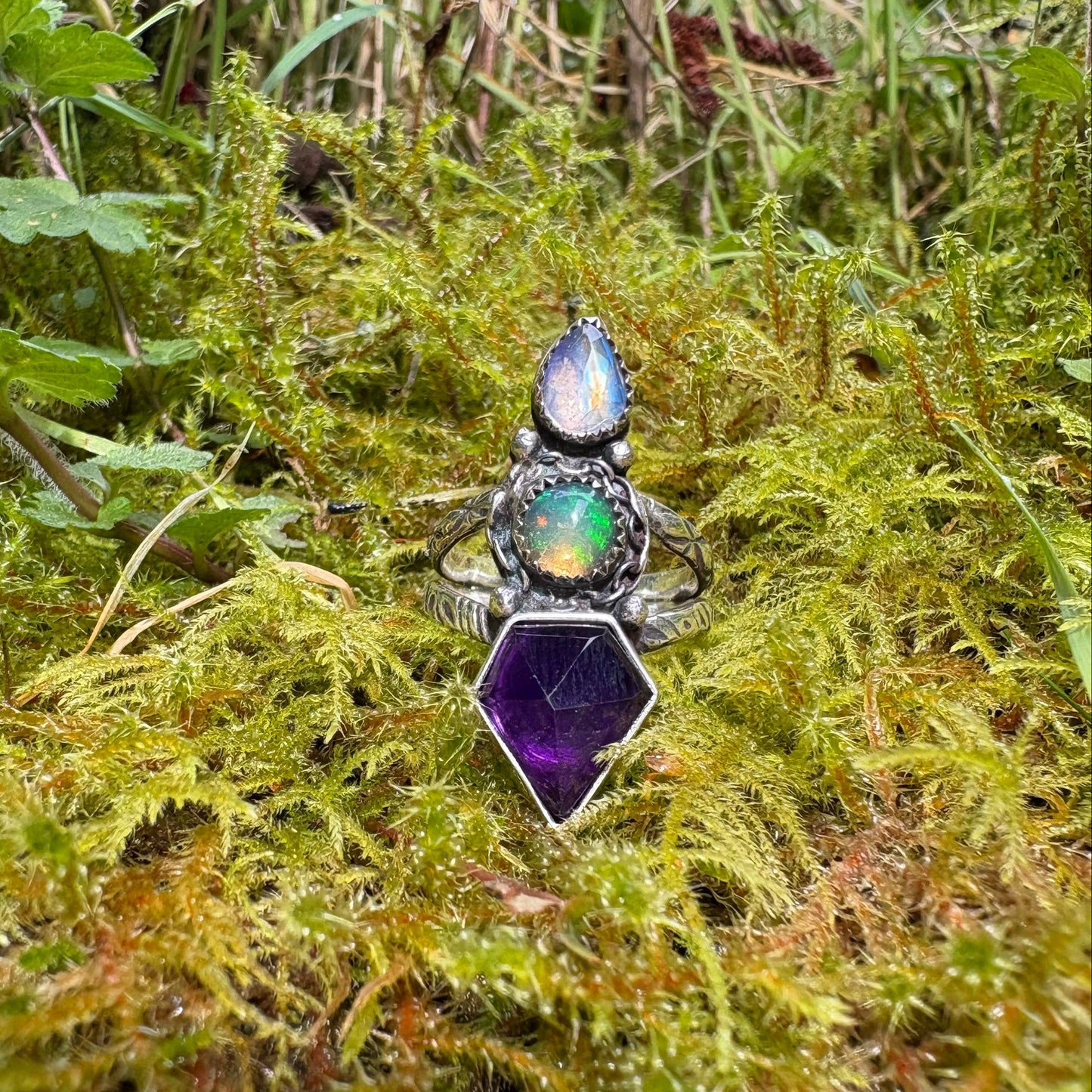 chunky triple gemstone ring with purple amethyst, opal and rainbow moonstone on a bed of moss